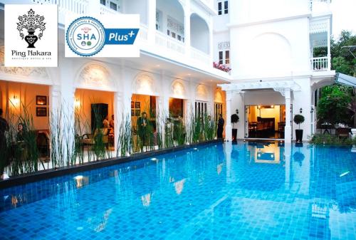 a swimming pool with a swimming pool table and chairs at Ping Nakara Boutique Hotel And Spa in Chiang Mai