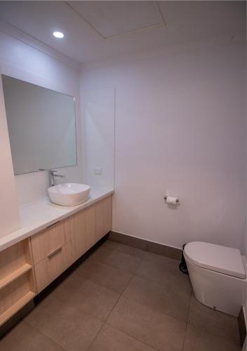 a bathroom with a sink and a toilet and a mirror at Snow Gum Apartment 2 in Baw Baw Village