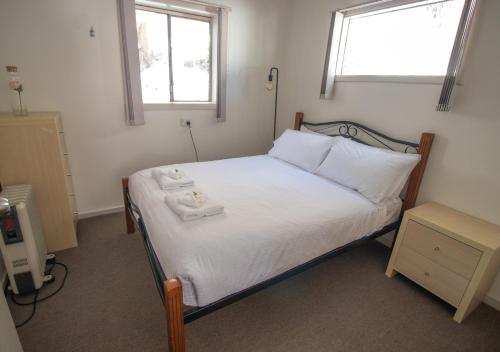 um quarto com uma cama com duas toalhas em Snow Gum Apartment 2 em Baw Baw Village