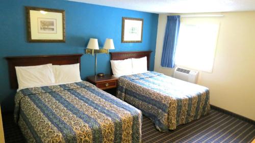 a hotel room with two beds and a window at Budget Host Airport Inn in Waterville