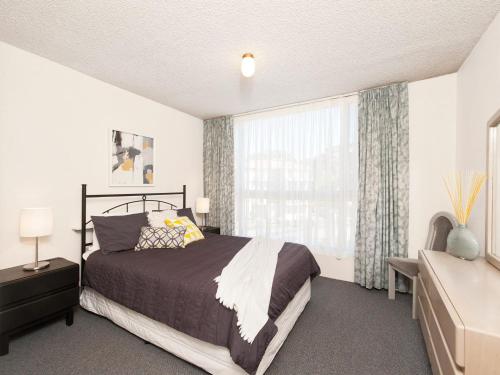 a bedroom with a bed and a large window at Ocean Shores Unit 10 27 Weatherly Close in Nelson Bay
