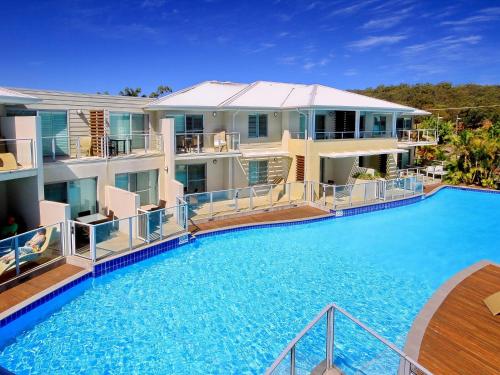 a large swimming pool in front of a house at Pacific Blue Apartment 258, 265 Sandy Point Road in Salamander Bay