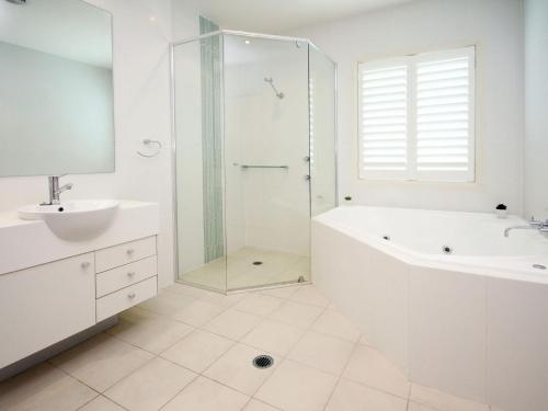 une salle de bain avec une douche, une baignoire et un lavabo dans l'établissement Pacific Blue Apartment 258, 265 Sandy Point Road, à Salamander Bay