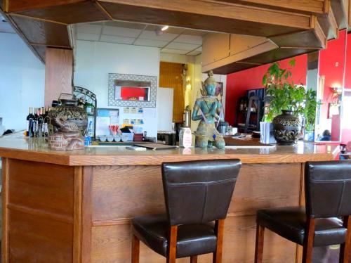 a bar with three chairs sitting at a counter at Budget Host Airport Inn in Waterville