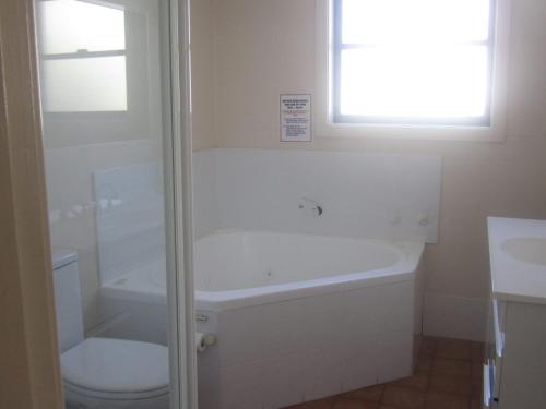 a bathroom with a tub and a toilet and a sink at Palm Beach 33B Shoal Bay Road in Shoal Bay