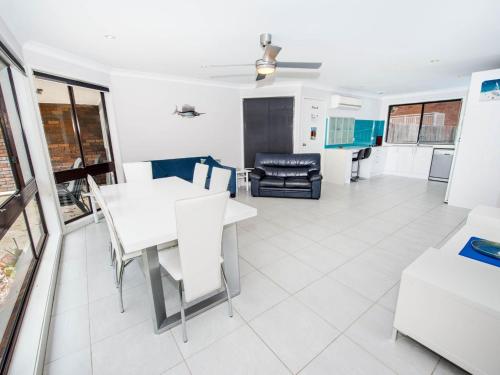 ein Esszimmer und ein Wohnzimmer mit einem Tisch und Stühlen in der Unterkunft Pet Friendly Tomaree Rd 142 Shoal Bay in Shoal Bay