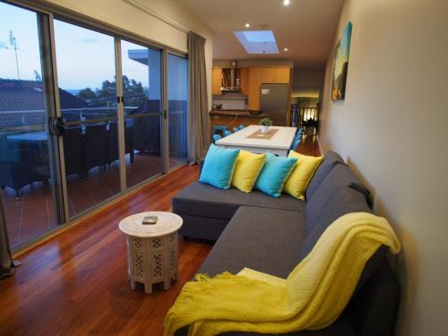 a living room with a couch and a table at Pollys View 117A Government Road in Nelson Bay