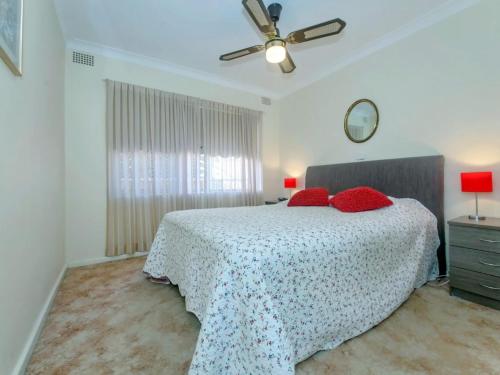 a bedroom with a bed with red pillows on it at Quarterdeck Unit 3 12 Magnus Street in Nelson Bay