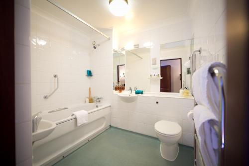 a bathroom with a tub and a sink and a toilet at Ellington Lodge at The Concorde in Eastleigh