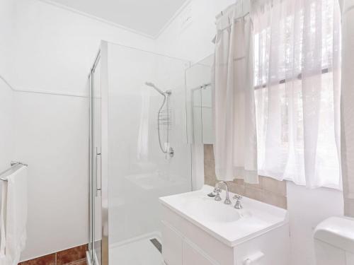 biała łazienka z umywalką i prysznicem w obiekcie Ronem Cottage 5 Gloucester Street w mieście Nelson Bay