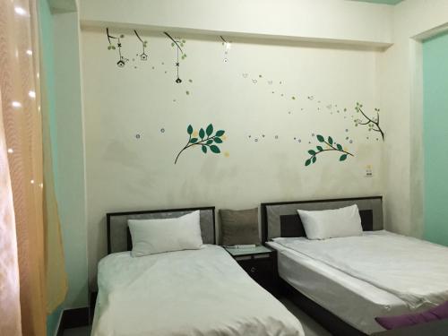 two beds in a room with music notes on the wall at Guanshan Fukuda Homestay in Guanshan