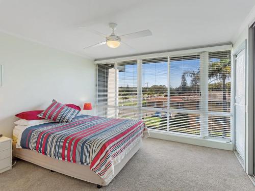 1 dormitorio con cama y ventana grande en Cirrus 6 44 Marine Drive, en Fingal Bay
