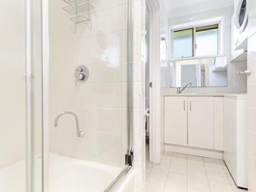 a white bathroom with a shower and a sink at Collendina Unit 6 19 Kurrawa Close in Nelson Bay