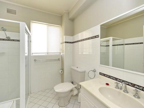 a white bathroom with a toilet and a sink at Del Rae Unit 12 25 Shoal Bay Road in Shoal Bay