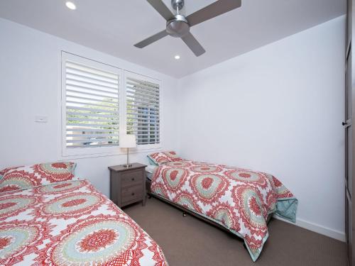a bedroom with two beds and a ceiling fan at Del Rae Unit 18 25 Shoal Bay Road in Shoal Bay