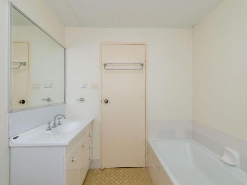 a white bathroom with a sink and a tub at Del Rae Unit 8 25 Shoal Bay Road in Shoal Bay
