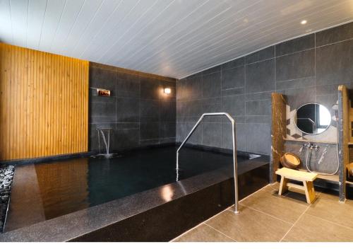 a bathroom with a bath tub with a sink at Staybridge Suites Bangkok Thonglor by IHG in Bangkok