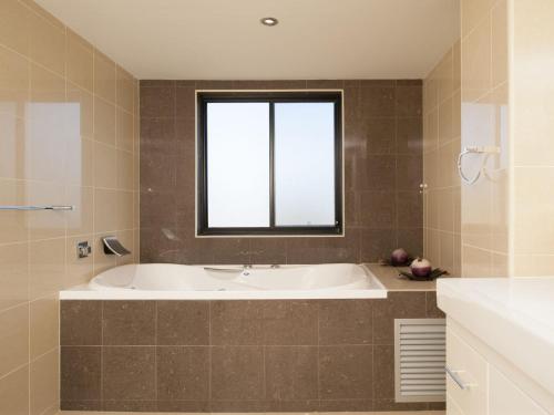 Un baño con bañera y ventana. en Government Road, Dolphin Cove, Unit 13, 2-6, en Nelson Bay