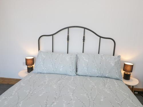 a bed with white sheets and two lamps on tables at Hilderthorpe House in Bridlington