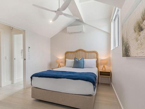 um quarto com uma cama e uma ventoinha de tecto em Key Court 17 em Noosa Heads