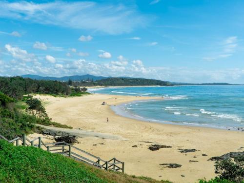 a beach with people on the sand and the ocean at Sand Sea 5 in Sawtell