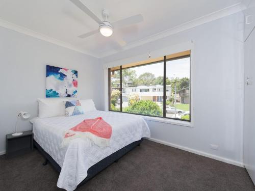 una camera da letto con un letto e una finestra di Eden by the Bay 98 Sandy Point Road a Corlette