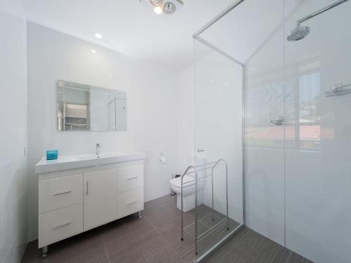 un bagno con wc, lavandino e doccia di Eden by the Bay 98 Sandy Point Road a Corlette