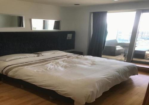 a bedroom with a white bed with a large window at SEA AIR OCEAN VILLAGE in Gibraltar