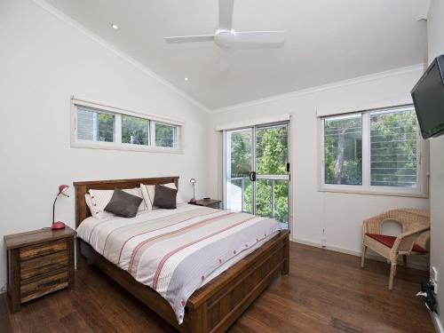 a bedroom with a large bed and windows at Florida 5 5 Lillian Street in Shoal Bay