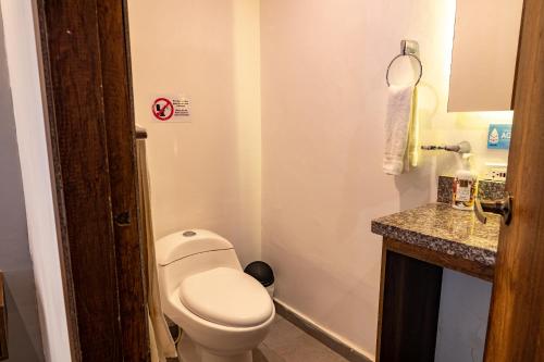 a small bathroom with a toilet and a sink at Hotel Amoek in Cartagena de Indias