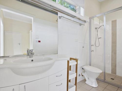 a white bathroom with a sink and a toilet at Fairwater In Mollymook in Mollymook