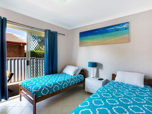 a bedroom with two beds and a view of the ocean at Sandy Shores 1 3 Messines Street in Shoal Bay