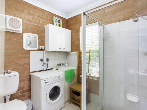 a bathroom with a washing machine and a shower at Sandy Shores 1 3 Messines Street in Shoal Bay