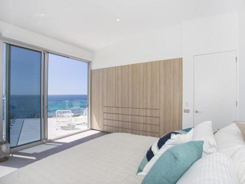a bedroom with a large bed and a large window at Bawley Point Beach Front in Bawley Point