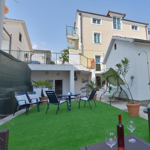 a patio with chairs and a table on a lawn at Solar Apartments in Herceg-Novi