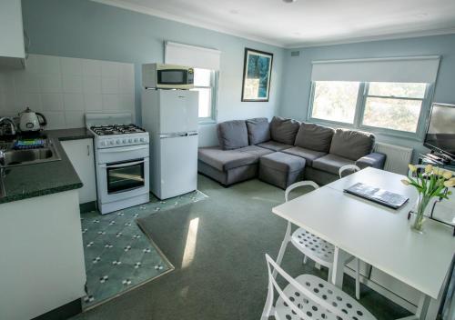 cocina y sala de estar con sofá y mesa en Altitude Apartment 1 en Baw Baw Village