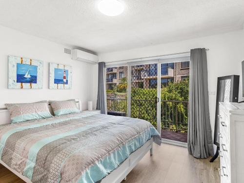 a bedroom with a bed and a large window at Yarramundi Unit 10 Magnus Street 47 49 in Nelson Bay