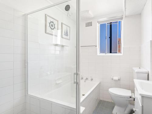 a white bathroom with a shower and a toilet at Yarramundi Unit 10 Magnus Street 47 49 in Nelson Bay