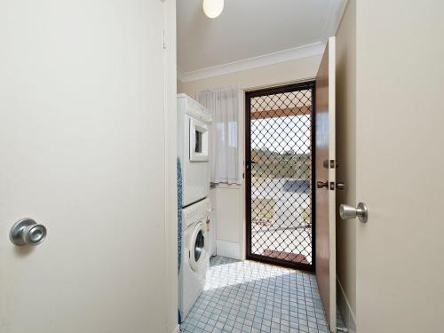 a door open to a laundry room with a washing machine at The Breakers 16B Government Road in Shoal Bay