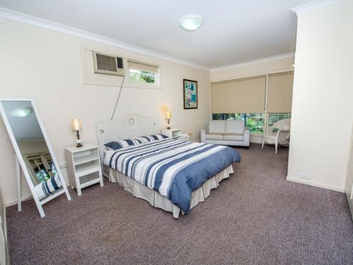 um quarto com uma cama, uma cadeira e uma janela em Shoal Bay Avenue Unit 3 7 em Shoal Bay