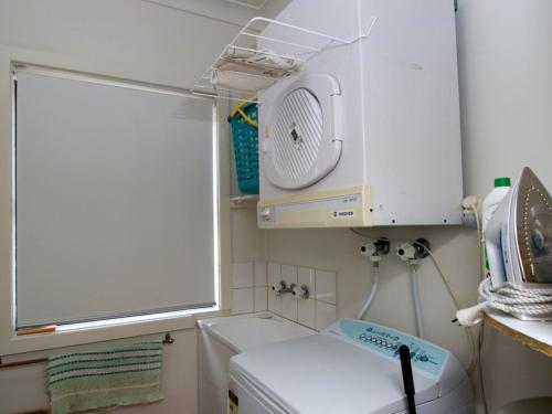 uma lavandaria com uma máquina de lavar roupa e uma janela em Shoal Bay Avenue Unit 3 7 em Shoal Bay