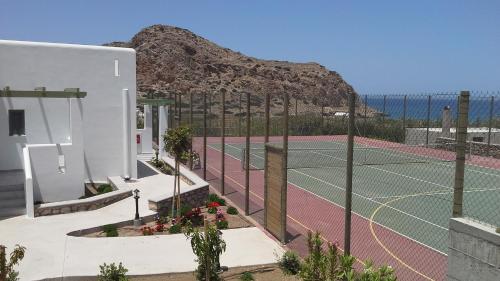 a tennis court in front of a building with two tennis courts at Alona Luxury Villas in Arkasa