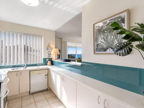 a kitchen with white cabinets and a large window at The Helm 4 22 Voyager Close in Nelson Bay