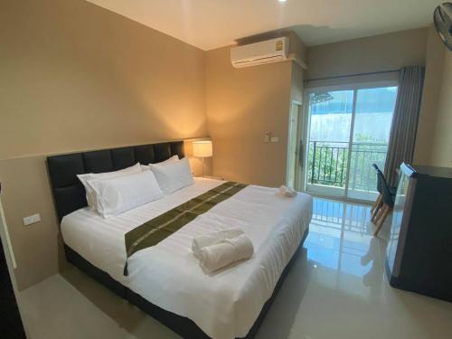 una camera da letto con un grande letto con una grande finestra di Kangaroo Residence Udonthani a Udon Thani