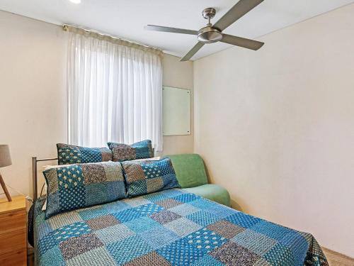 a bedroom with a bed and a ceiling fan at Shoal Towers Unit 3 11 Shoal Bay Road in Shoal Bay