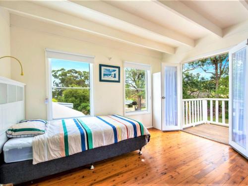 A bed or beds in a room at Tallwoods Beach House