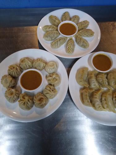 two plates of dumplings and two cups of dipping sauce at Best Hostel in Kathmandu