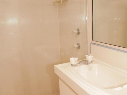 a white bathroom with a sink and a shower at Seaside Serenity Soldiers Point in Soldiers Point