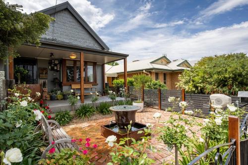 a home with a garden with a fountain in the yard at Cabo’s On Currajong Warm, Cosy and Welcoming in Parkes