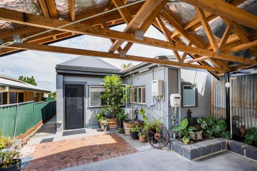 a house with a wooden pergola and some plants at Cabo’s On Currajong Warm, Cosy and Welcoming in Parkes